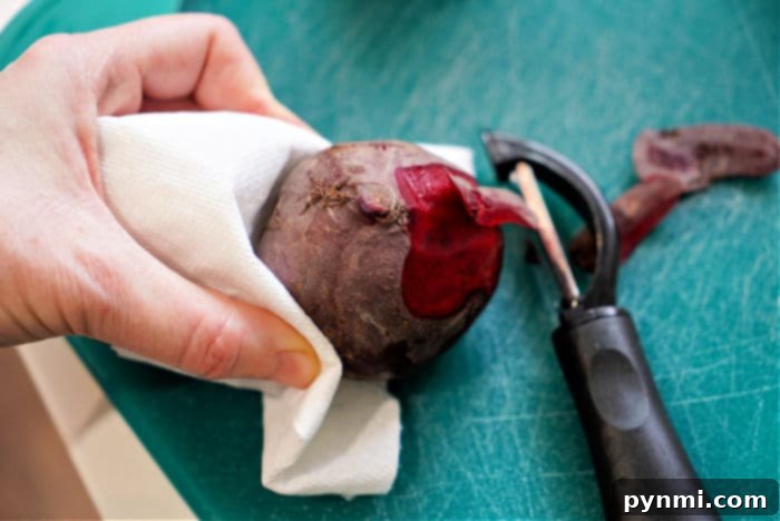 Sweet and Tender Air Fryer Beets 4 Hands peeling red beets with a vegetable peeler