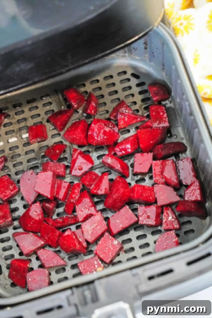 Sweet and Tender Air Fryer Beets 8 Diced red beets placed in an air fryer basket, ready for cooking. These air fryer beets are spread out evenly across the perforated surface.