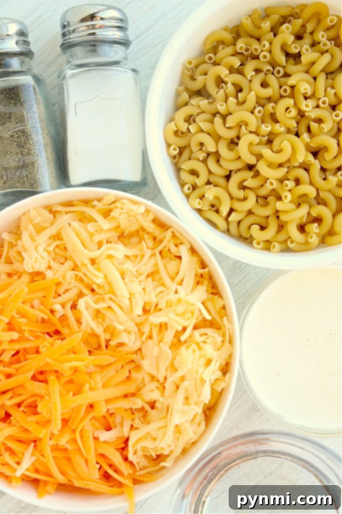 Ingredients for air fryer macaroni and cheese laid out on a wooden surface.