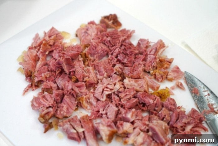 Ultimate Instant Pot 15-Bean Comfort 3 Chopped ham on a white cutting board with a knife beside it, ready to be added to the soup.