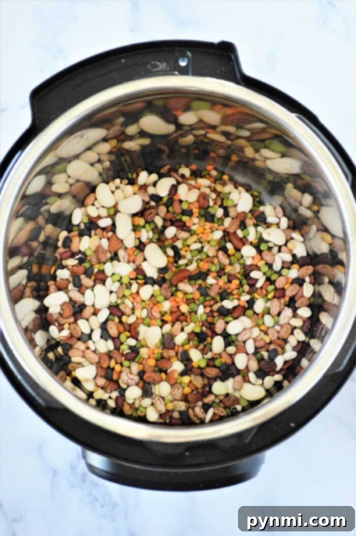 Ultimate Instant Pot 15-Bean Comfort 5 Instant Pot 15 bean soup sits invitingly on a marble countertop, showcasing its hearty mix of flavors and rich textures.