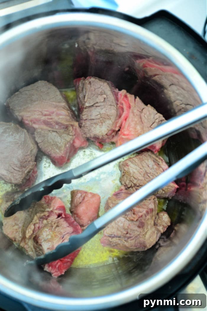 Mouthwatering Instant Pot Barbacoa 4 Searing beef in Instant Pot – close-up of beef chuck roast browning in the inner pot of a pressure cooker, creating a rich crust.