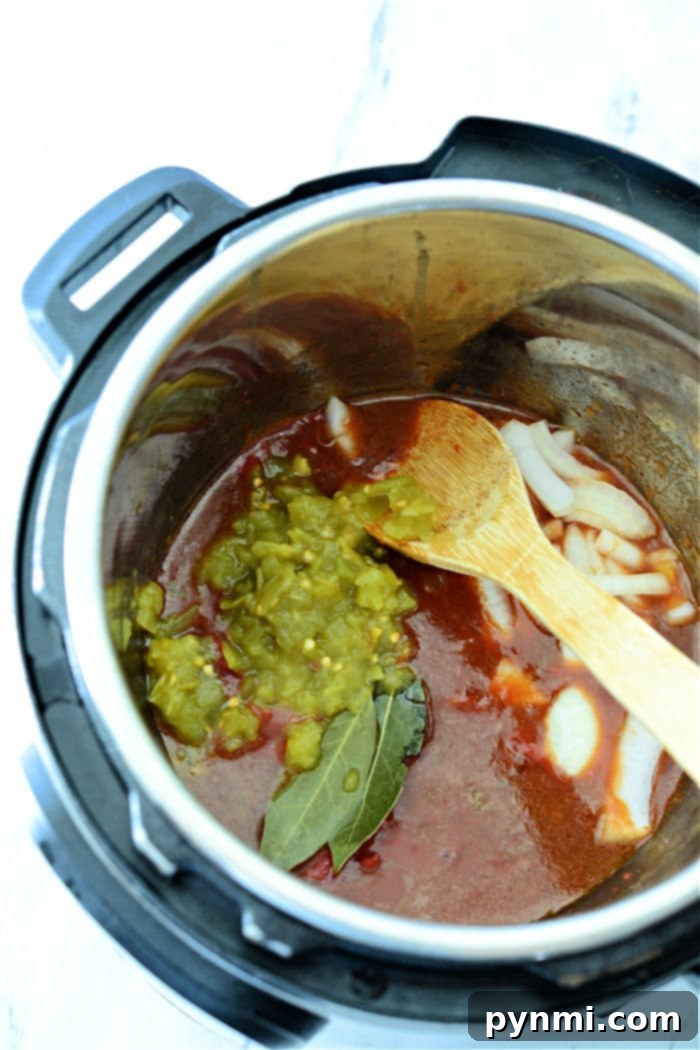Mouthwatering Instant Pot Barbacoa 7 Pressure Cooker Beef – A large pot of shredded pressure cooker beef, glistening with sauce and ready to be served.