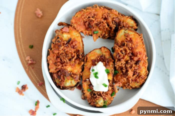 double stuffed potatoes - An overhead shot of three loaded potato skins on a cutting board, garnished with fresh chives, indicating they are ready for serving.