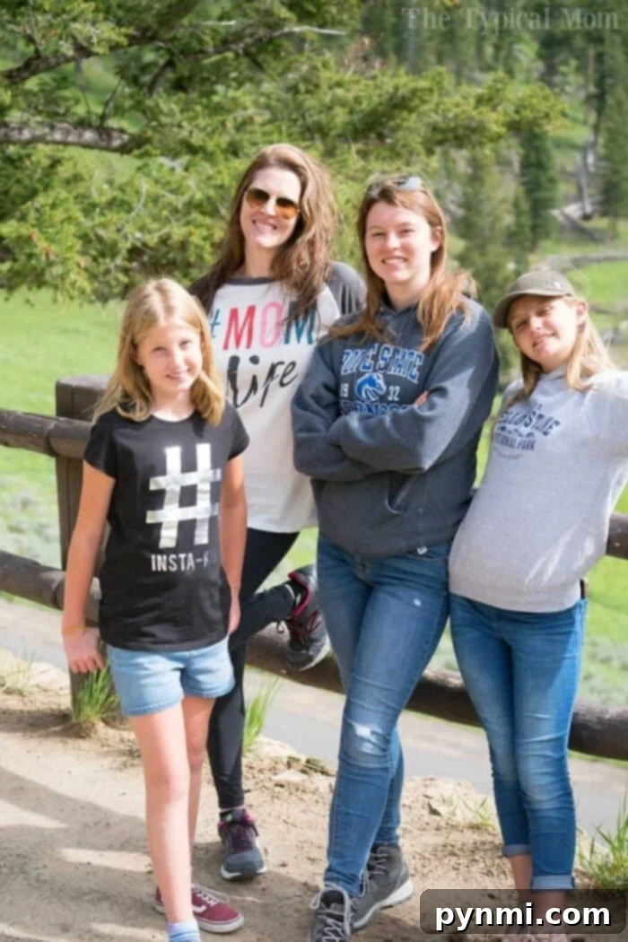 Four people posing casually outdoors by a wooden fence with lush greenery in the background, perhaps discussing how to start homeschooling.