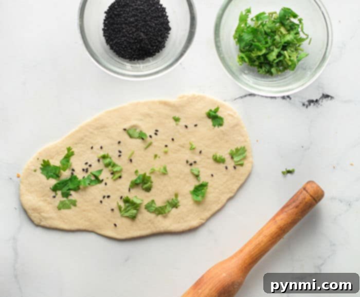Pillowy Soft Air Fryer Naan 5 Hand rolling out naan dough on a lightly floured surface.