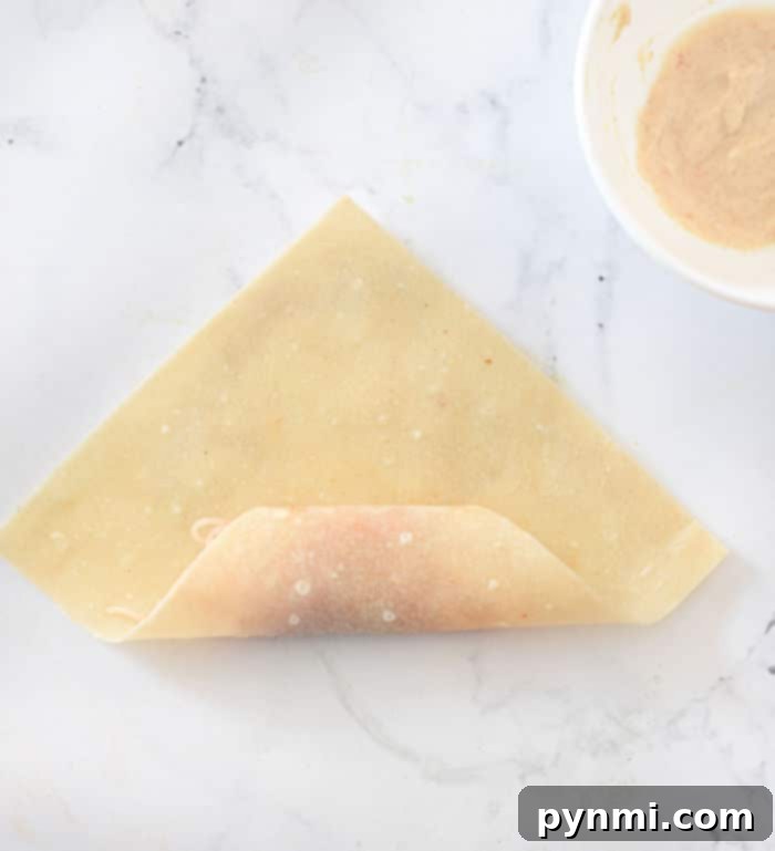Crispy Homemade Egg Roll Wrappers from Scratch 6 Filling placed on an egg roll wrapper ready for folding