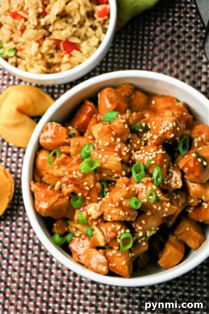 Flavorful Asian Chicken 2 Instant Pot Asian Chicken, a bowl of flavorful chicken served with rice and garnished with green onions.