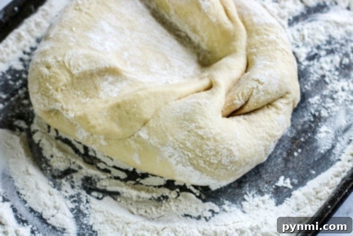 Close-up of a bowl of soft, elastic sweet roll dough after its first rise.