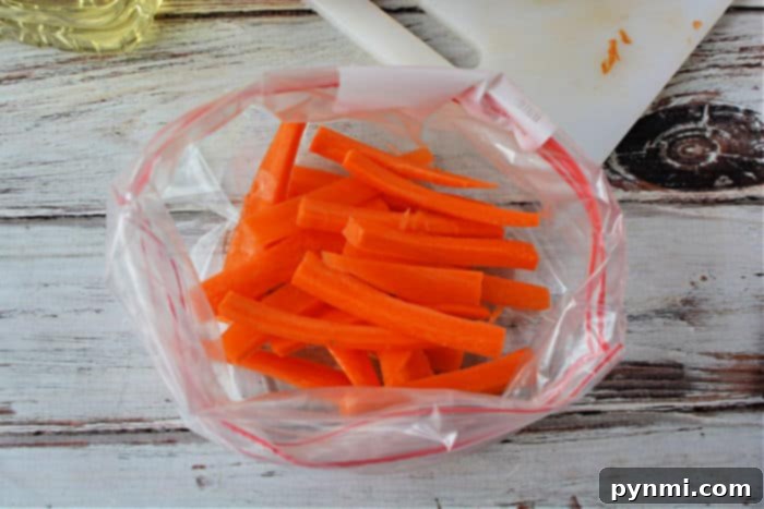 Crispy Air Fryer Carrot Fries 4 Carrot fries cooking in an air fryer basket