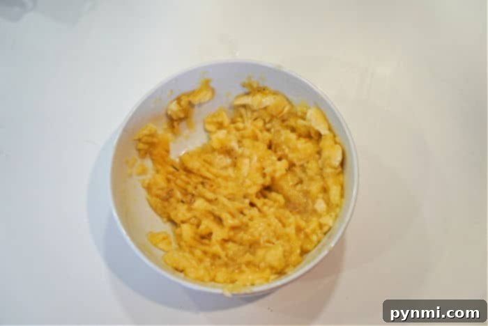 Close-up of mashed overripe bananas, showing a few delightful chunks for texture.