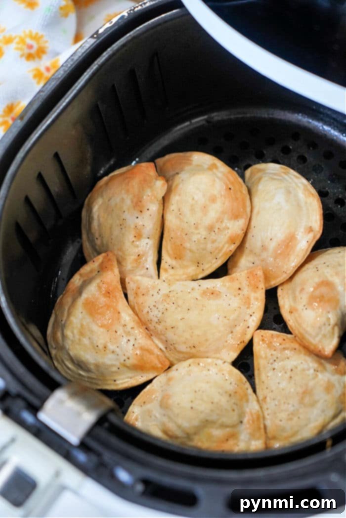 Golden-brown, perfectly cooked frozen pierogies in an air fryer basket, ready to be served.