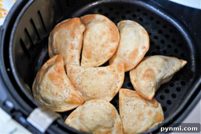 A basket full of golden-brown frozen pierogies cooked to perfection in an air fryer.