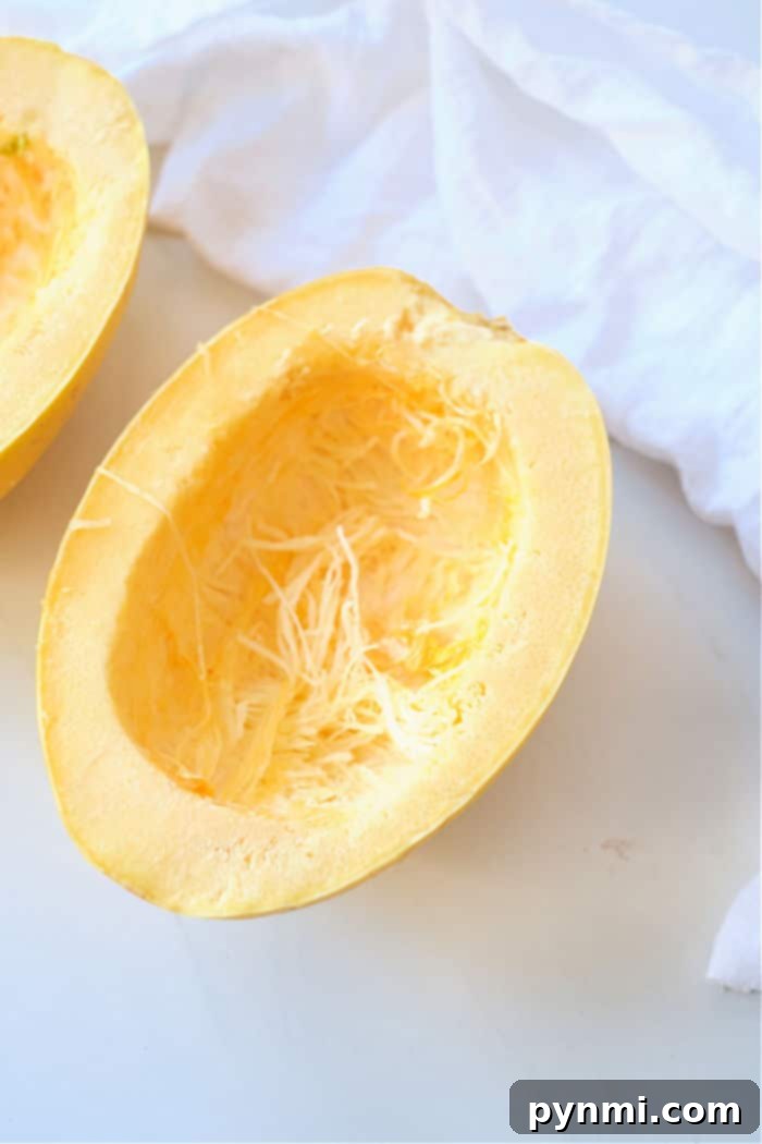 Perfectly Roasted Air Fryer Spaghetti Squash 3 Freshly cut spaghetti squash halves, with seeds removed, ready for seasoning.