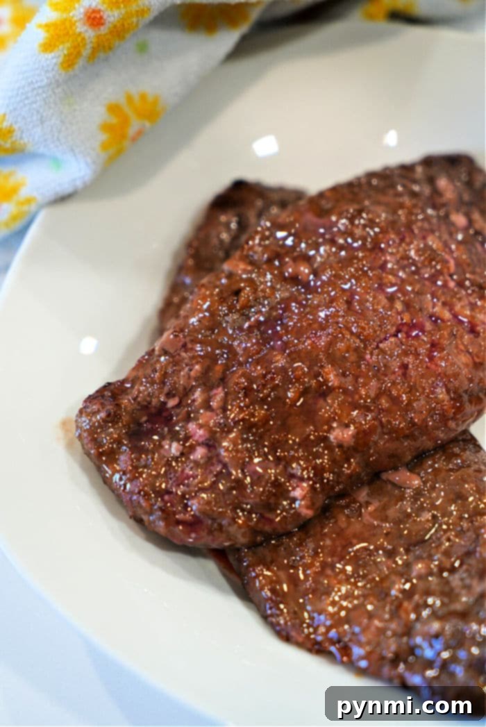 Crispy Golden Air Fryer Cube Steaks 9 Close-up of raw minute steak slices on a white plate, perfect for preparing into air fryer cube steak with a mallet.