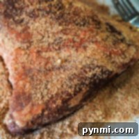 Ultimate Tri-Tip Seasoning 8 A seasoned tri-tip, perfectly coated with a flavorful dry rub, rests on a white surface, ready for cooking.