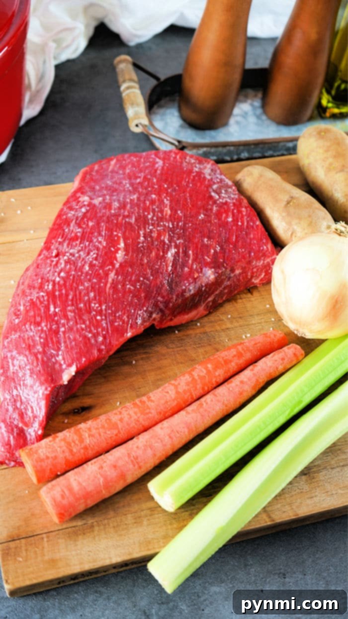 Slow Braised Dutch Oven Tri Tip 3 Raw tri tip, carrots, celery, onion, and potatoes sit on a wooden cutting board near salt and pepper shakers, ready to transform into a hearty Dutch oven tri-tip meal.