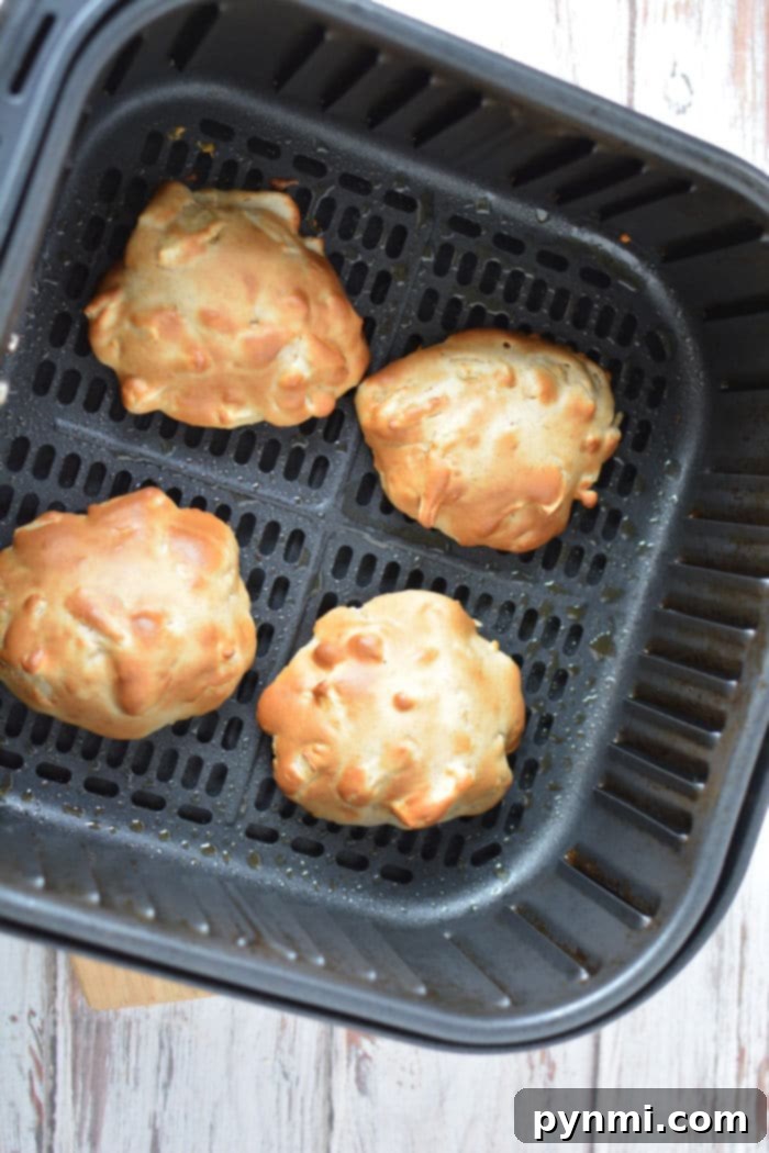 Warm, glazed apple fritters presented beautifully in an air fryer basket, ready to be enjoyed.