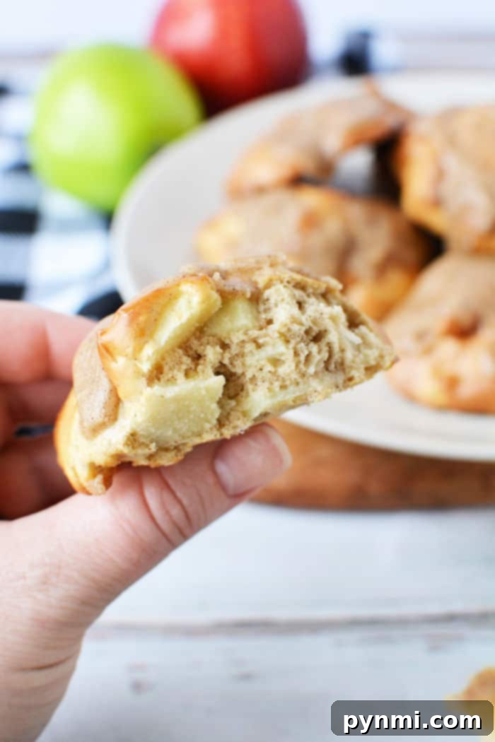 Air fryer apple fritters with a delicate glaze and cinnamon dusting, displayed on a wooden board.