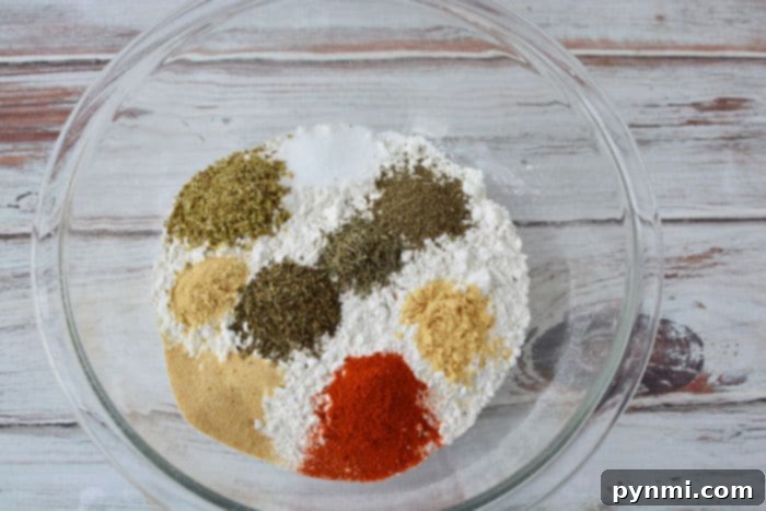 Close-up of a bowl filled with seasoned flour mixture, the perfect breading for fried chicken.