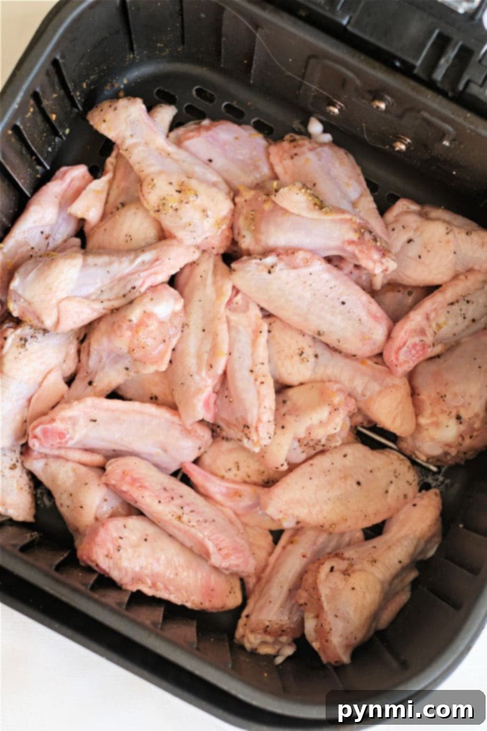 Ninja Foodi air fryer basket filled with cooked lemon pepper chicken wings.