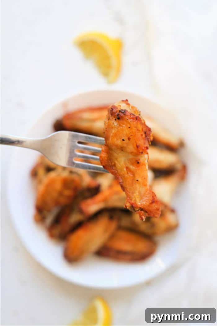 Assortment of chicken wings cooking in an air fryer basket.