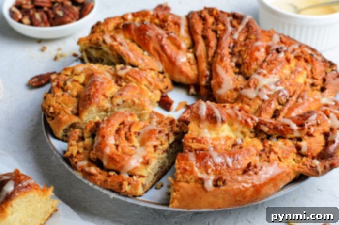 Beautiful Braided Bread 9 The golden brown baked cinnamon pull apart wreath bread, glistening with a maple syrup glaze, cooling on a wire rack.