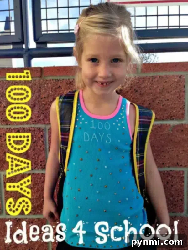 Smiling child proudly wearing a DIY '100 Days of School' shirt adorned with colorful craft items.