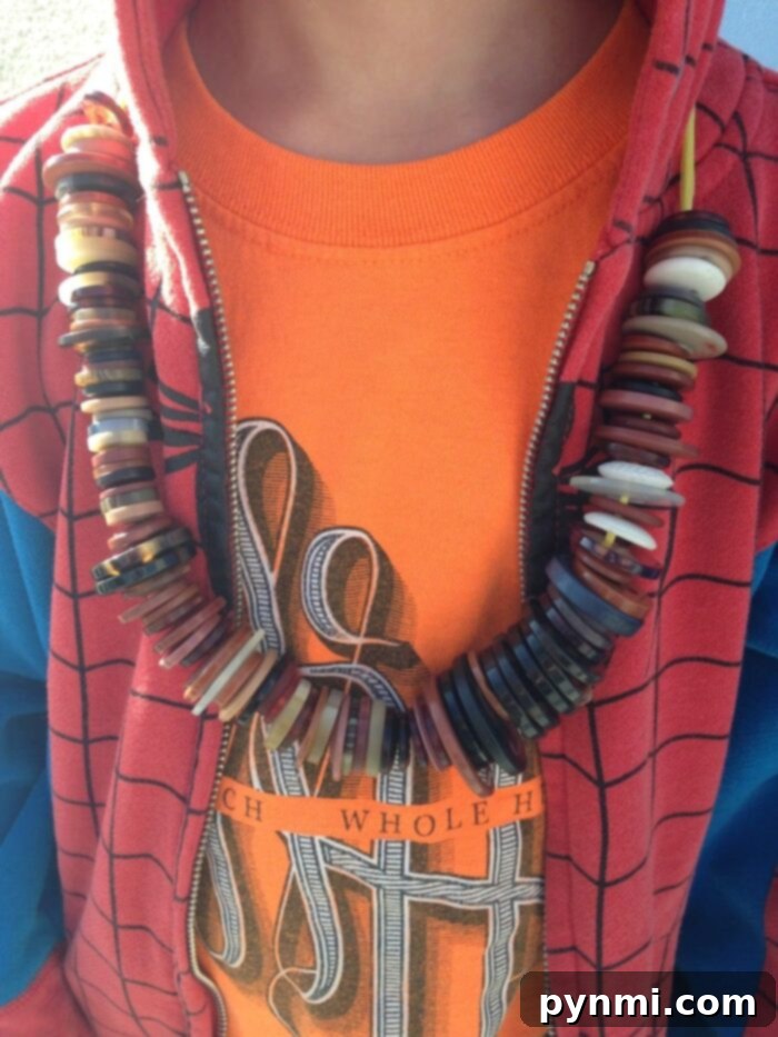 Child proudly displaying a homemade '100 Days of School' shirt adorned with colorful buttons and string.