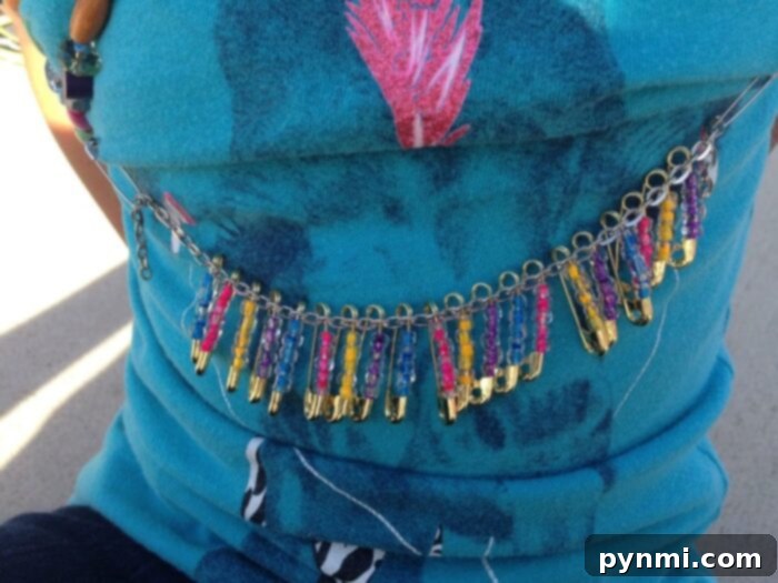 A young girl smiling brightly in a '100 Days of School' shirt decorated with assorted craft items, ideal for creative DIY.