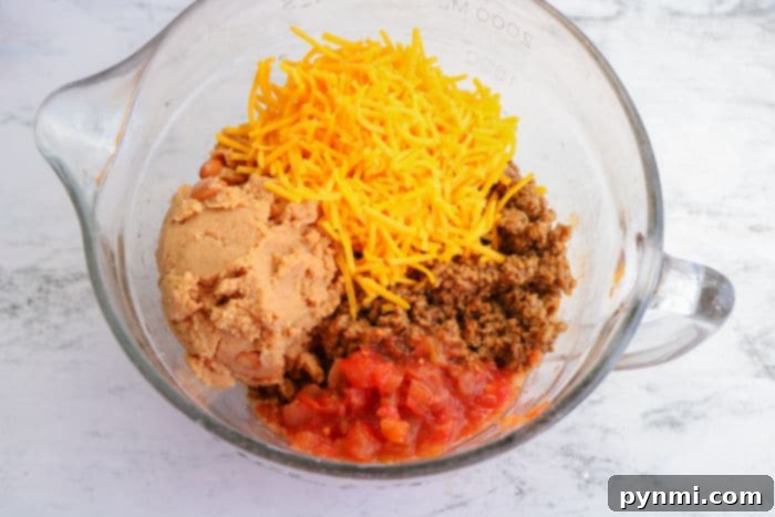 Crispy Air-Fried Flautas 5 Close-up of a bowl filled with a seasoned ground beef mixture, ideal for filling air fryer taquitos or flautas, with a spoon nestled inside.