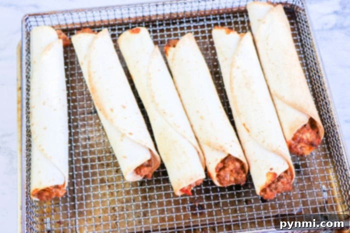 Crispy Air-Fried Flautas 8 Freshly cooked, golden-brown air fryer homemade flautas arranged on a white plate, ready to be served.