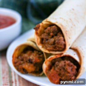 Crispy Air-Fried Flautas 9 Three crispy air fryer flautas rest on a white plate with a side of salsa, placed on a striped cloth, making a perfect meal.