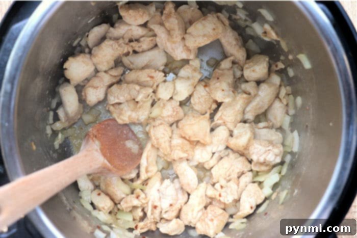 Instant Pot Mexican Fiesta Chicken and Rice 6 Instant Pot filled with browned chicken, ready for the next steps of the Mexican chicken and rice recipe.