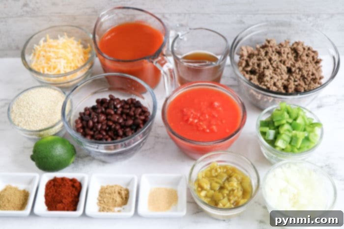A top-down view of a slow cooker filled with the raw ingredients for enchilada casserole, including ground beef, black beans, diced tomatoes, bell peppers, onions, quinoa, and various spices, ready for cooking.