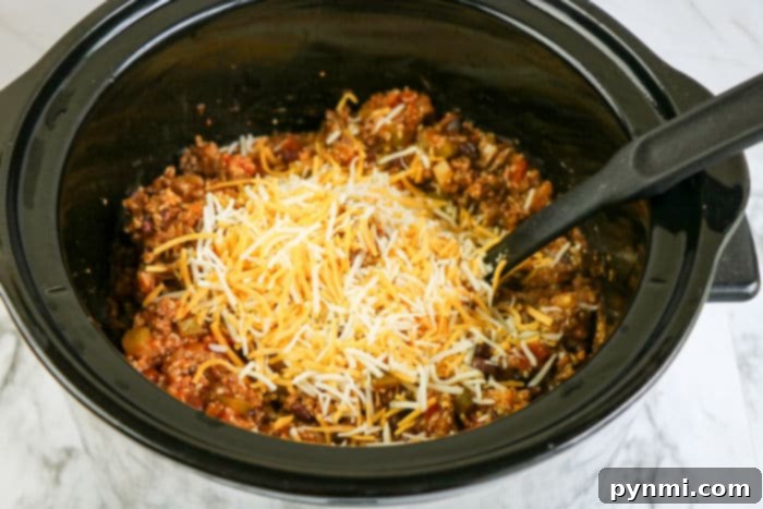 A vibrant and cheesy crockpot Mexican casserole, topped with fresh cilantro, ready to be served.