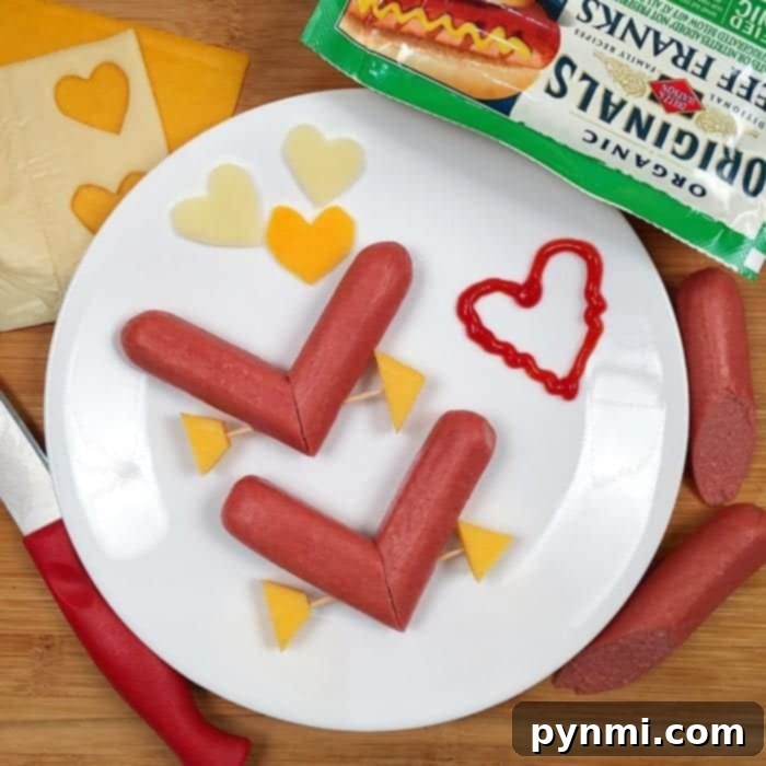 An inspiring Valentine's dinner idea for kids, featuring inexpensive heart hot dogs and fun Valentine craft inspiration. Heart-shaped hot dogs served with a side of vegetables and a festive drink, a complete cute Valentine's dinner idea.