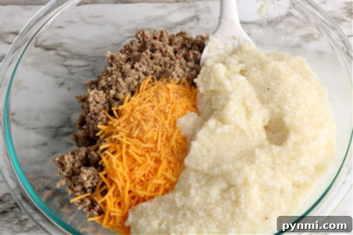 Ultimate Cheesy Grits Bake 4 Close-up of creamy grits with melted cheddar cheese, ready for a delicious recipe.