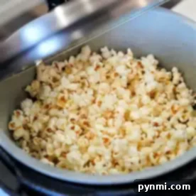 A pot filled with freshly popped popcorn inside an open Ninja Foodi pressure cooker.