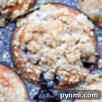 Close-up of blueberry muffins with a crumb topping for muffins, beautifully baked in a metal muffin tray.