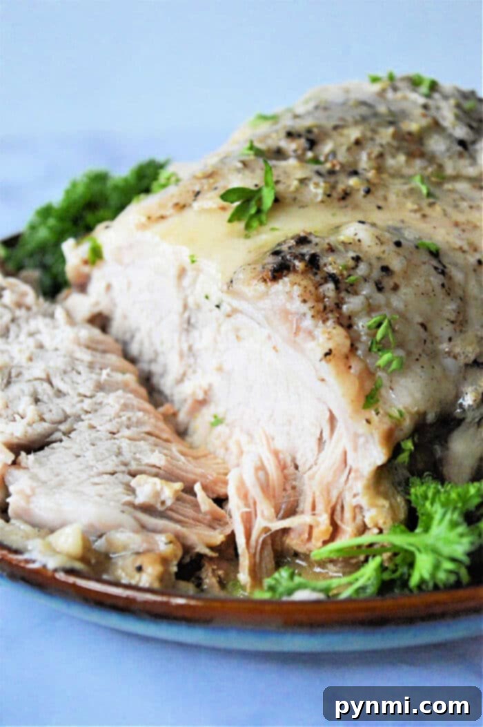 Ultimate No-Thaw Instant Pot Pork Roast 7 Frozen pork roast cooked in an Instant Pot with herbs, sliced and served on a plate garnished with fresh parsley.