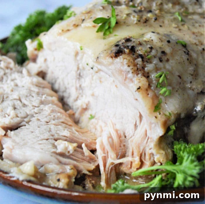 Ultimate No-Thaw Instant Pot Pork Roast 9 Sliced seasoned pork roast with herbs and parsley on a plate, reminiscent of a freshly cooked meal, is quick and easy to prepare, much like using an instant pot for your favorite frozen pork roast.
