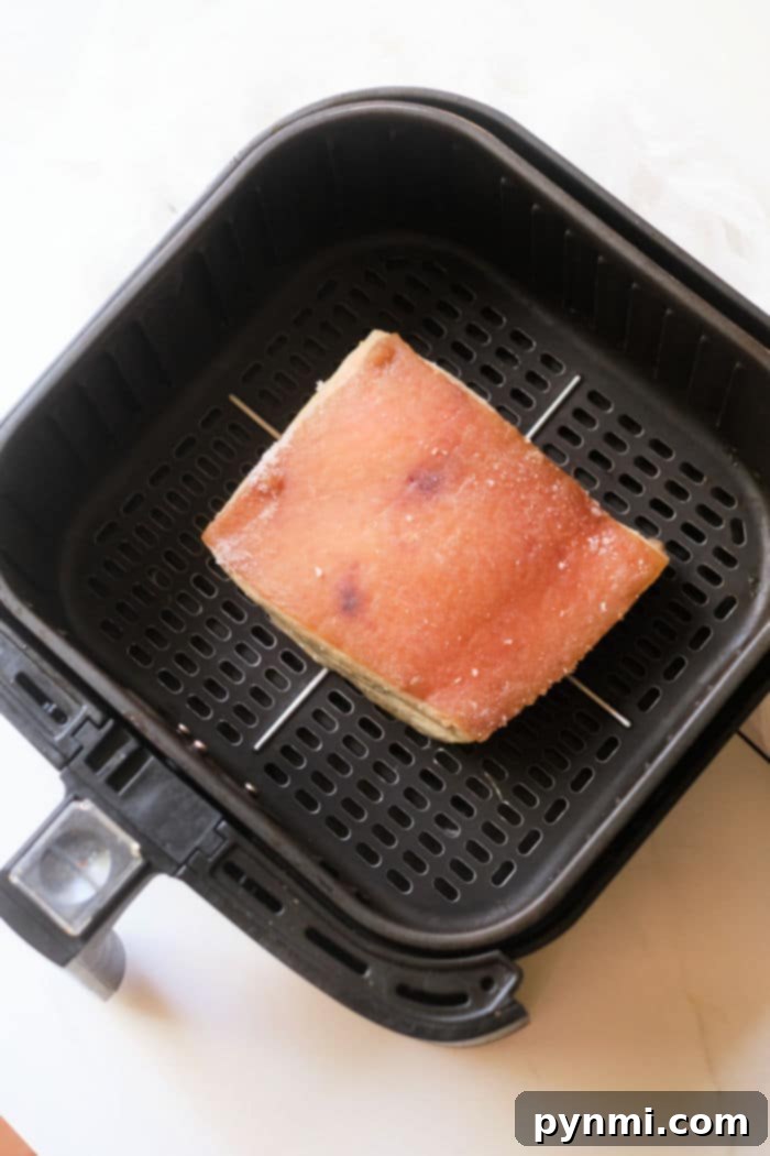Quick & Tender Instant Pot Pork Belly 6 A slice of pork belly being toasted inside an air fryer basket pairs perfectly with the savory flavors of instant pot pork belly.