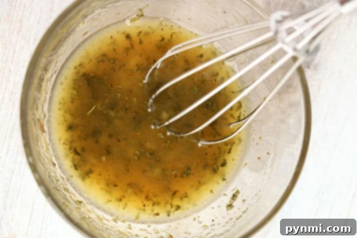 A close-up of a simple salmon marinade with garlic, butter, and herbs, ready to be brushed onto frozen salmon fillets.