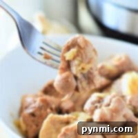 A fork holding a tender piece of pork adobo hovers above a bowl brimming with flavorful chunks, all effortlessly prepared in an Instant Pot.