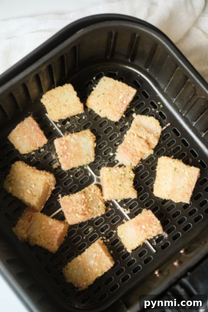 Crispy Air Fryer Fish Tacos 4 Arrangement of uncooked breaded fish pieces, fresh lime wedges, and cilantro, ready for air frying and taco assembly.