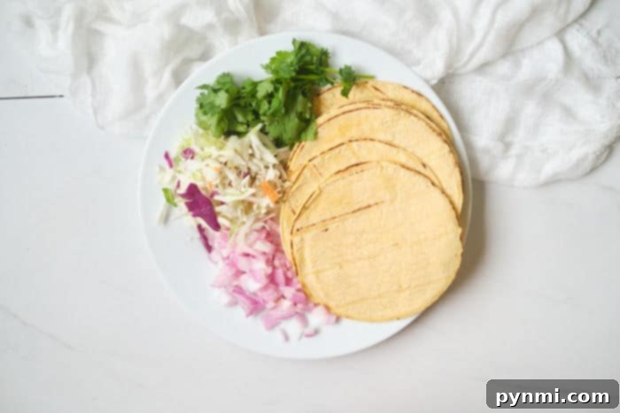 Crispy Air Fryer Fish Tacos 5 A vibrant fish taco bar spread with various toppings, sauces, and fresh ingredients, ready for guests to customize their tacos.