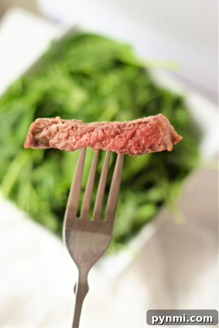 Perfectly cooked ribeye steak sliced and ready to serve, showing its juicy medium-rare interior, cooked in an air fryer.