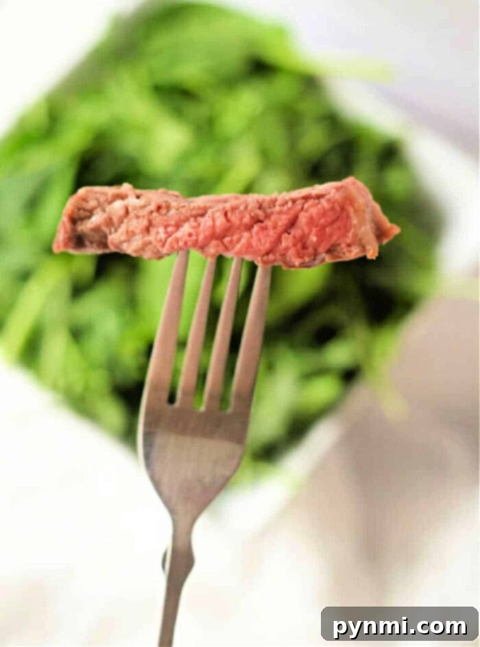 Raw, well-marbled ribeye steak on a cutting board, prepared for air frying, demonstrating ideal fat distribution for maximum flavor.