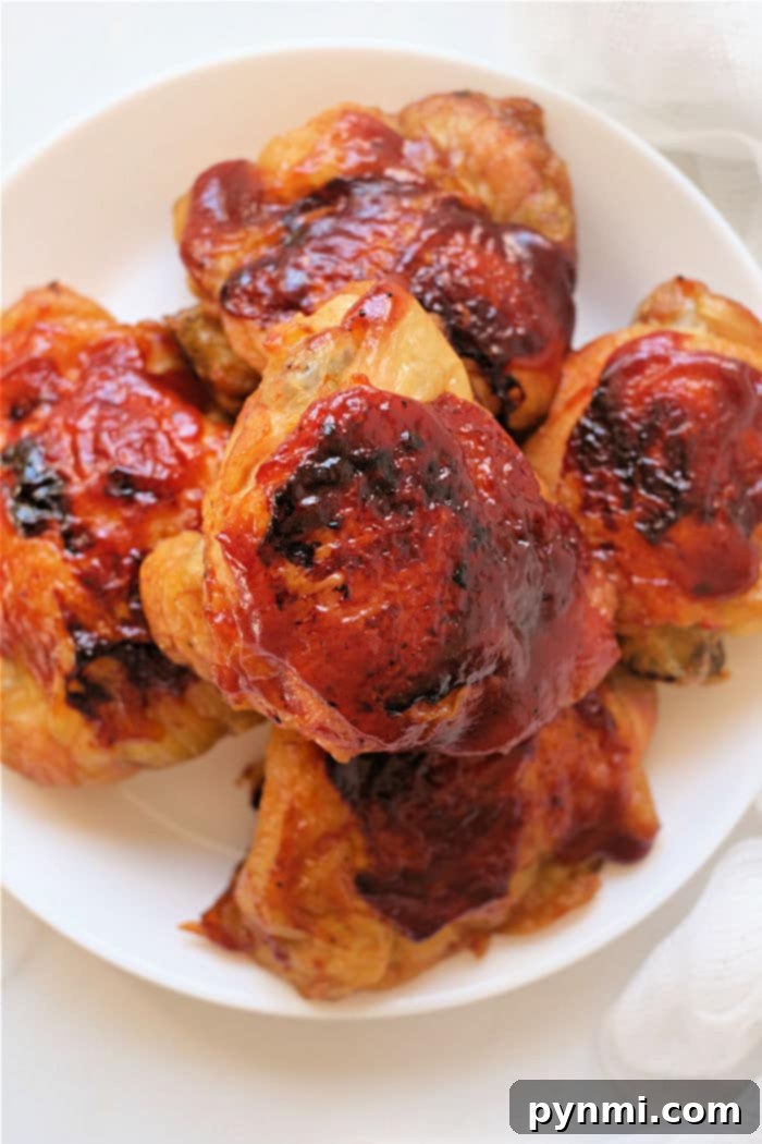Mastering Frozen Chicken Thighs in Your Air Fryer 2 Frozen chicken thighs perfectly cooked in an air fryer, glazed with barbecue sauce and garnished with fresh herbs, ready to serve.